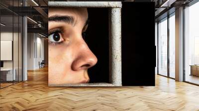 A prisoner staring out of a small barred window, with a distant expression, reflecting on the outside world and the reality of imprisonment Wall mural