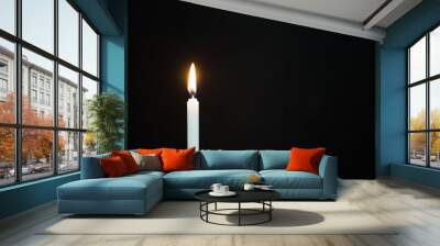 One light candle burning brightly on black background Wall mural