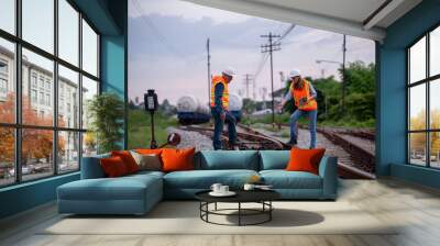 Engineer railway engaged in discussion or inspection maintenance work greenery and gas or oil power industrial or transportation setting in the rail train import export logistics industry concept. Wall mural