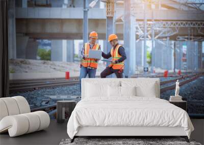 Engineer under discussion inspection and checking construction process railway switch and checking work on railroad station .Engineer wearing safety uniform and safety helmet in work. Wall mural