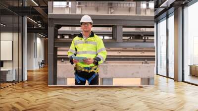 Engineer under inspection and checking construction process railway switch and checking work on railroad station .Engineer wearing safety uniform and safety helmet in work. Wall mural