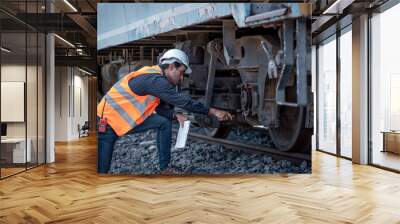 Engineer under  inspection and checking construction process railway switch and checking work on railroad station .Engineer wearing safety uniform and safety helmet in work. Wall mural