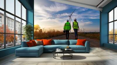 Engineer wearing uniform hold equipment box inspection work in wind turbine farms rotation to generate electricity energy. Green ecological power energy generation wind sustainable energy concept. Wall mural