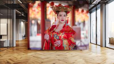 Portrait happiness young beautiful Asian woman wear red cheongsam dress costume holding red fan on hand celebration on Chinese festival. Wall mural