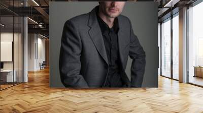 Portrait of a handsome businessman in a suit on a dark studio background. Wall mural