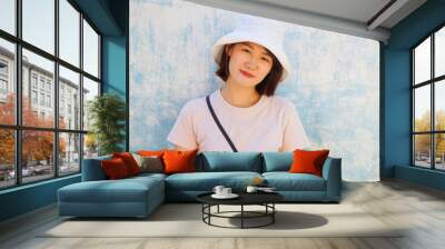 happy face of traveler, young asian woman with blue and white vintage wall as background with copy space. Wall mural