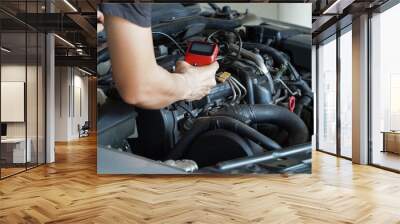 Mechanic is using a diagnostic car code reader. Wall mural