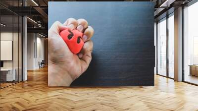 a ball of stress relief in a hand on brown background Wall mural