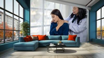 A woman in a blue shirt is being comforted by a woman in a white lab coat Wall mural