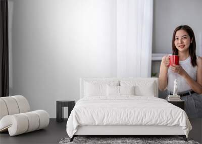 Young asian businesswoman drinking coffee in office Wall mural