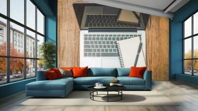 Blank notebook computer with notepad and pen on wooden floor Wall mural