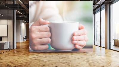 Woman hand in warm sweater holding a cup of coffee.Web banner. Wall mural