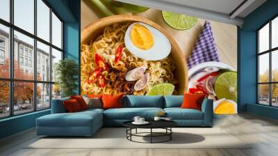 Instant noodles in wooden bowl and vegetable side dishes on wood table background. Wall mural