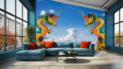 Twin golden chinese dragon statue in blue sky background Wall mural