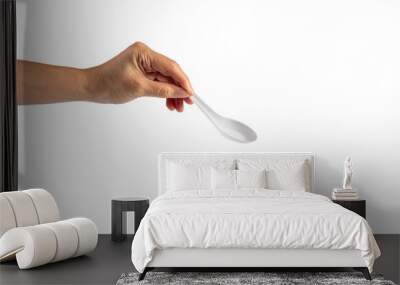 White plastic soup spoon in hand on transparent background Wall mural