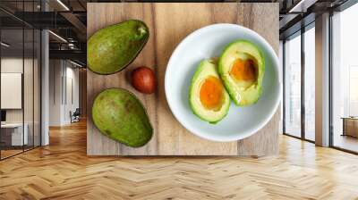 Top view of avocado cut in half, Topped with honey in white ceramic bowl placed on wood table, Healthy food and health care concept. Wall mural