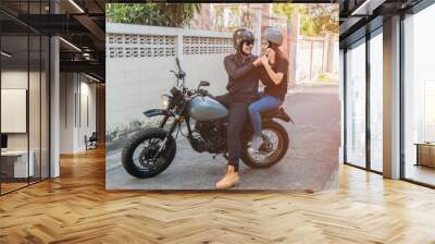 Asian handsome biker wearing helmet and wearing helmet to girlfriend Wall mural