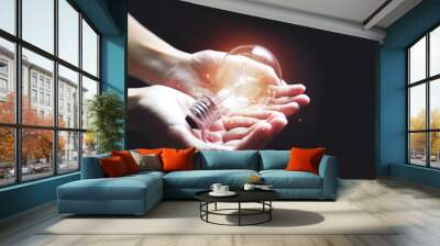 Shining light bulb on hand with growing light for creative idea using concept. Creativity photo for inspiration thinking of way. Wall mural