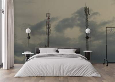 Two towers with antennas and a device for providing communication to move on the background of the sky at dusk. Wall mural