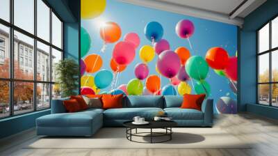 A bunch of colorful balloons soaring into the bright blue sky with confetti, representing joy and celebration on a sunny day. Wall mural