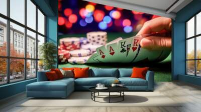 Hand revealing cards in a high stakes poker game with casino chips in the background. Wall mural