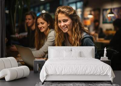 Young smiling woman working on laptop at a busy cafe with friends in the background. Wall mural