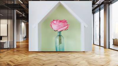 Single pink rose in blue vintage bottle. House-shaped box with flower inside. Wall mural