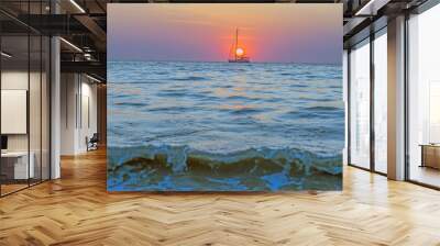 Picture of a sailing yacht on the sea in front of the setting sun in back light Wall mural