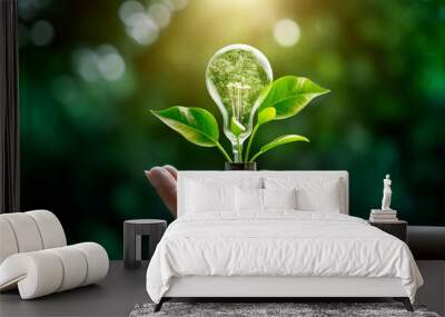 green energy concept. hand holding green plant bulb with green tree in the background Wall mural