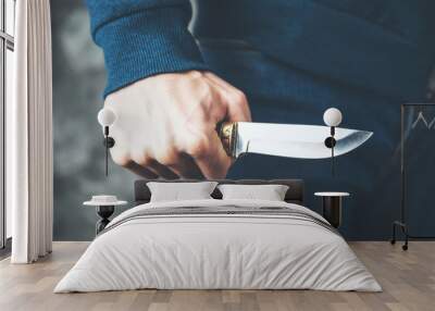 man hand knife on dark background Wall mural