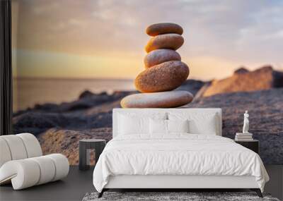 Stones pyramid on the seashore at sunset Wall mural