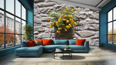 Pot with yellow flowers on a stone wall Wall mural