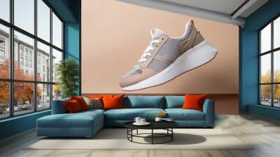 beige gray leather female sneakers with lace isolated on beige background flying fashion stylish casual sneakers sports unisex clothing shoes advertising minimal mockup with footwear Wall mural