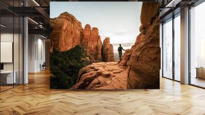 Horizontal wide angle view of woman standing at sunset from Cathedral Rock in Sedona. Wall mural