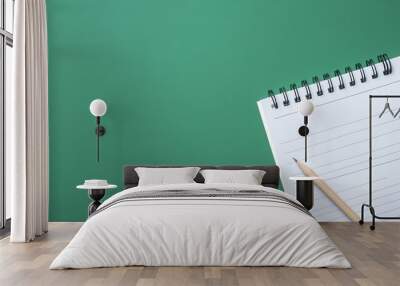 A blank lined notebook with a pencil on a green surface Wall mural