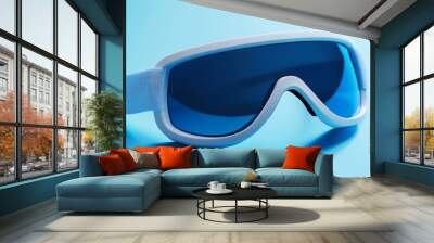 White Ski Goggles with Blue Lenses on Blue Background Wall mural