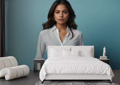 Calm Hispanic female model in white blouse and slacks on light blue background Wall mural