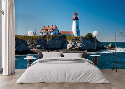 Coastal lighthouse with rocky cliffs and bright blue sky Wall mural