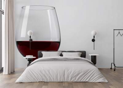 Elegant glass of red wine resting on a plain white background. Wall mural