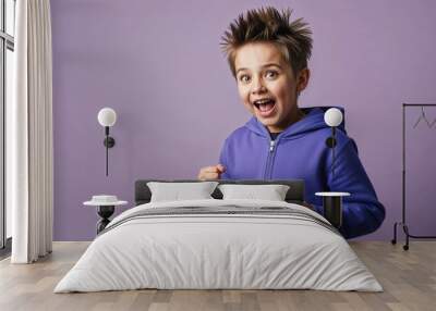 Excited young Caucasian boy with spiky hair wearing tshirt on plain grey background Wall mural