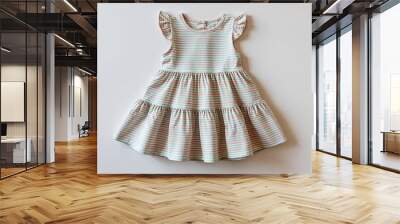 Small pastel striped dress for kid girls with tiered skirt on plain white background Wall mural