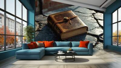 Worn leather bound book resting on a cracked stone windowsill Wall mural