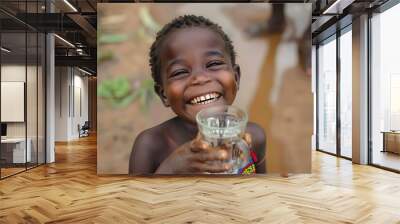 Close-up of a joyful child in Africa drinking water from a mug, highlighting the issue of drought and lack of water Wall mural