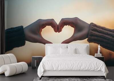 Couple making heart shape with hands at sunset Wall mural