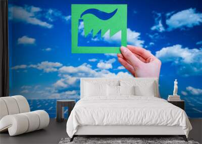 Hand holds green idustry symbol on solar panels background. Wall mural