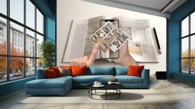 Augmented reality concept. Hand holding smartphone with AR application used to simulate 3d pop-up interactive house maps to life Wall mural