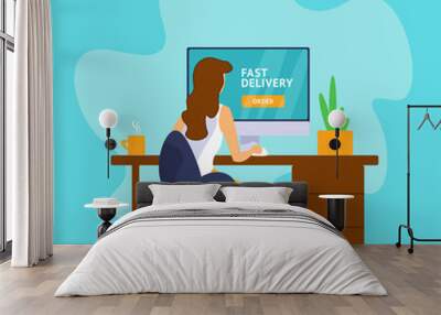 Young woman sitting at a computer and ordering home delivery in the online store Wall mural