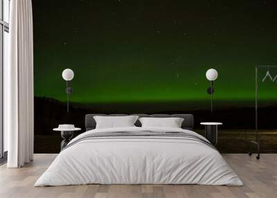 strong aurora borealis over snowy mountains and field in winter night Wall mural