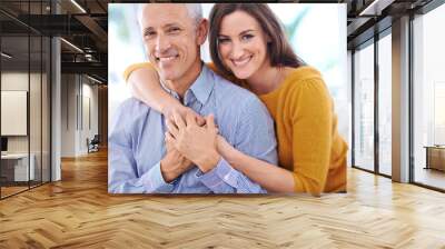 Happy, couple and hug in portrait, love with unique relationship and support for trust at home. Aged man, young woman and age difference in marriage, commitment and loyalty with pride together Wall mural