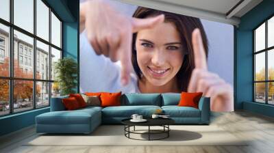 Portrait, smile and woman with finger frame, focus and studio for creative fashion photography. Perspective, hand gesture and girl showing happy face, casual style and view finder on blue background. Wall mural